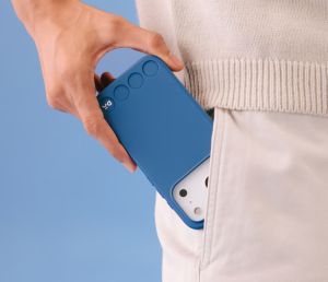 Hand placing a blue DailyObjects Stack Phone Case into a pocket — durable MagSafe-friendly Secret Santa gift for men.