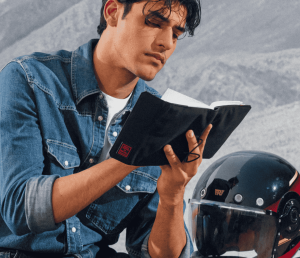 Man reading the Royal Enfield × DailyObjects Field Notebook — handcrafted journal perfect for thoughtful Secret Santa gifting.