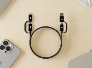SURGE Kevlar Core 4‑in‑1 100W fast-charging cable neatly coiled on a desk beside phone and laptop.