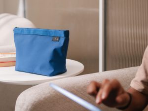 Pivot Carry All Pouch holding sunscreen, makeup, and travel accessories